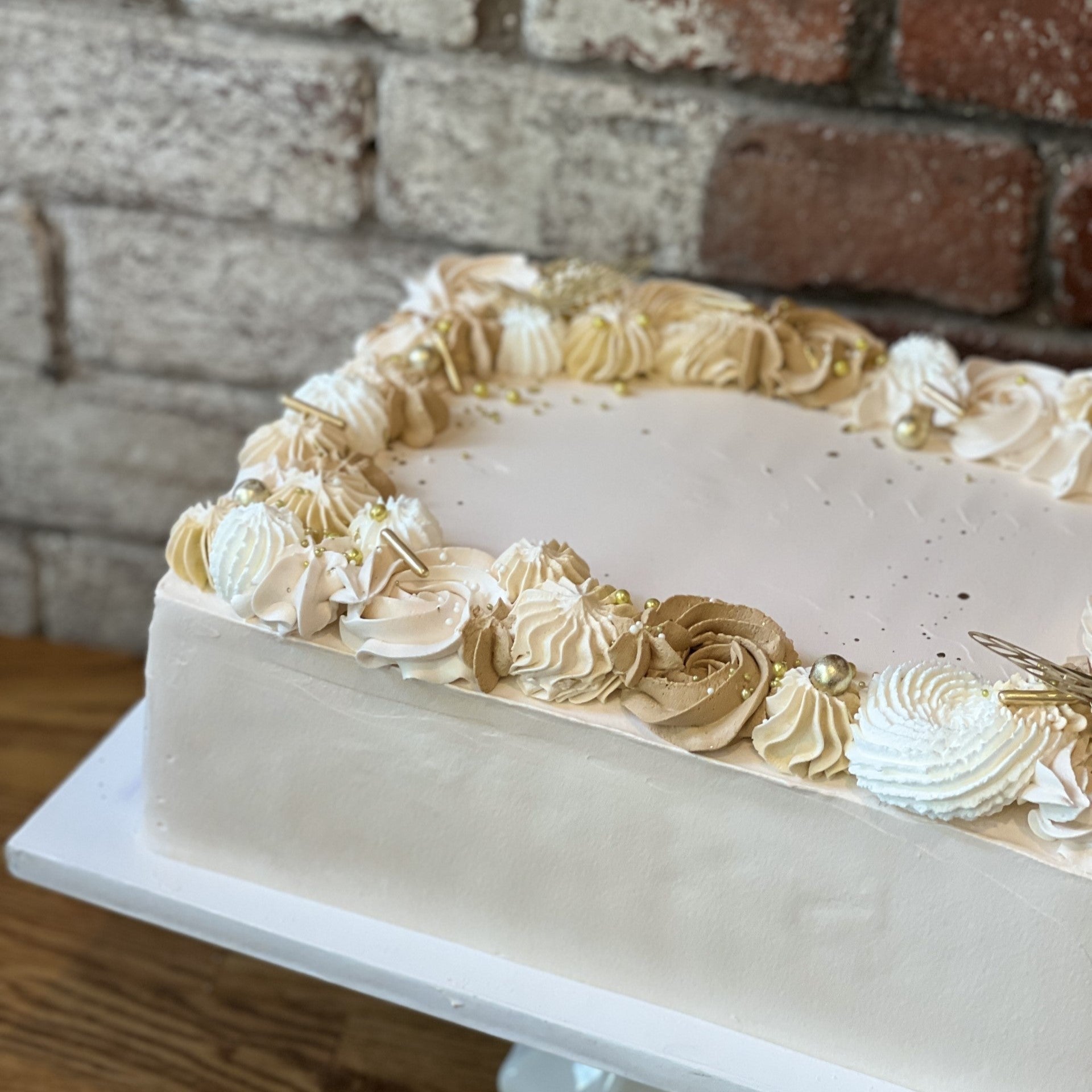 White sheet cake with gold design around the edges