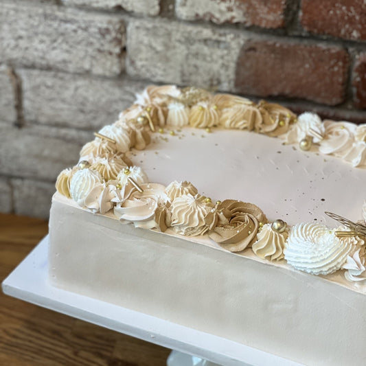 White sheet cake with gold design around the edges