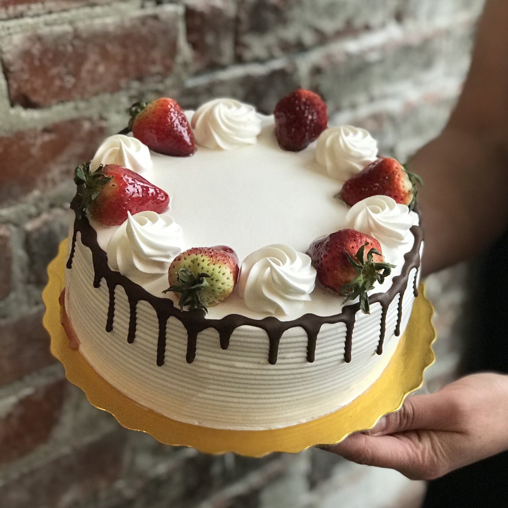 Vanilla cake with chocolate drip and fresh strawberries